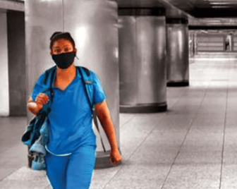 essential worker in an empty subway station during COVID